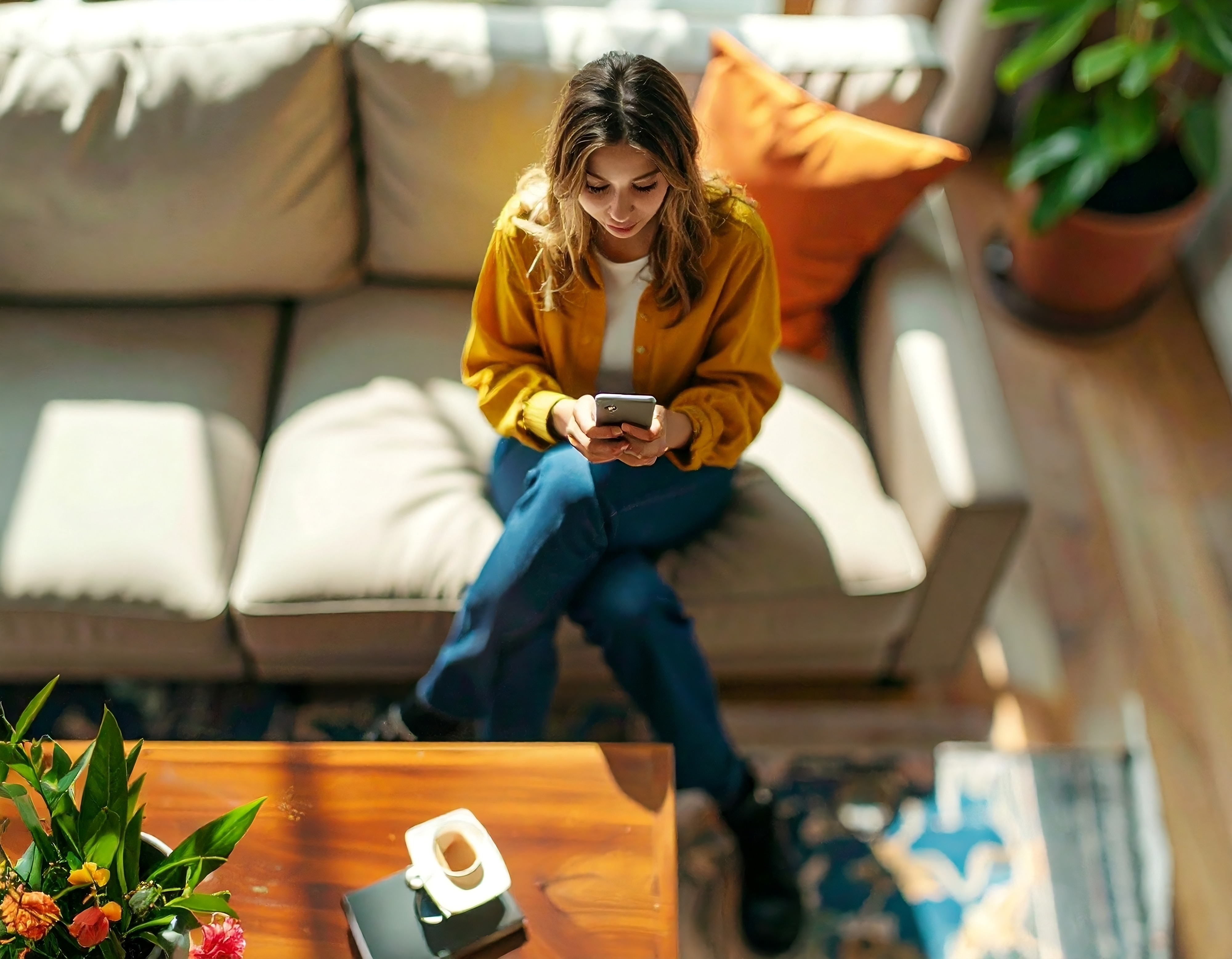Ragazza sul divano controlla il telefono